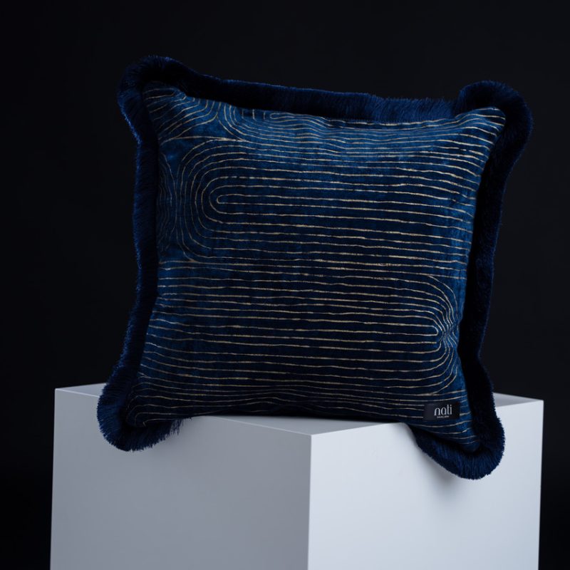 Nati Luxury Pillow Kissen 'Donatello Cité des Doges' – dunkelblauer Samt mit goldenem Wellenmuster und Plüschrand, freigestellt auf einem Podest